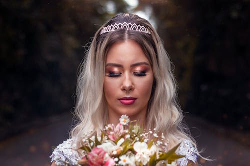 Photo of A Bride Holding a Bouquet of Flowers Stock Photo